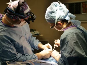 A photo of a surgical team performing a procedure on a patient.