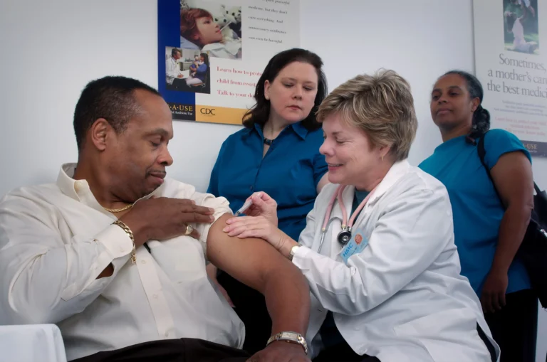 Doctor administering vaccine to patient in clinic.